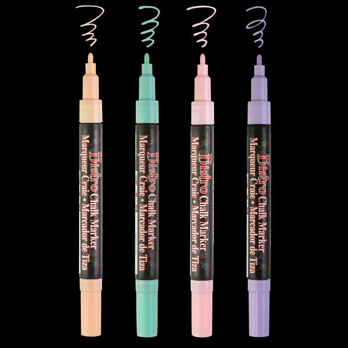 Marvy Uchida Bistro chalk marker four piece set uncapped; showing fine tips on a black background. Colors include pastel peach, peppermint, blush pink, and pale violet.
